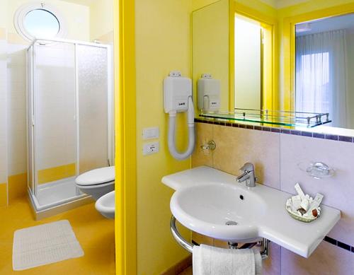 a bathroom with a sink and a shower and a toilet at Residence Levante in Misano Adriatico