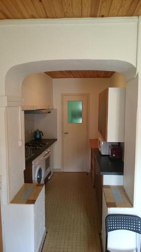 une petite cuisine avec une cuisinière et un micro-ondes dans l'établissement Villa Marguerite, à Ax-les-Thermes