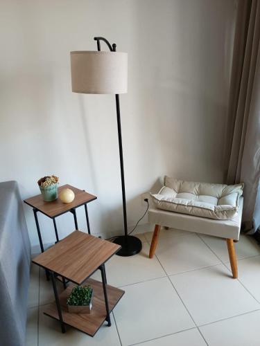 a living room with a couch and a lamp and a table at Suite, 2quartos, cozinha completa, varandão, 2 vagas de garagem in Niterói