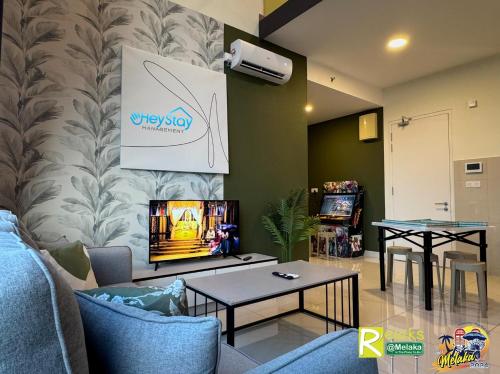a living room with a tv on a wall at The Apple Residence By Heystay Management in Melaka