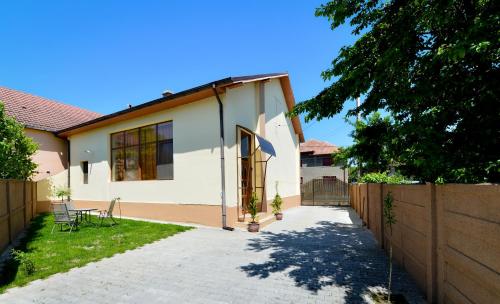 a white house with a fence and a driveway at Casa Ovi și Simo in Haţeg