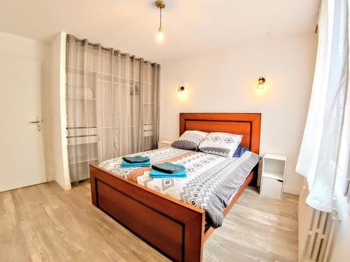 a bedroom with a bed with a wooden bed frame at Une halte, Proche Notre-Dame in Rodez