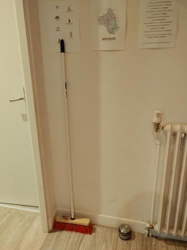 a broom in a room next to a wall at Une halte, Proche Notre-Dame in Rodez