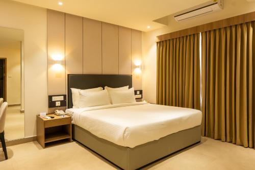 a hotel room with a bed and a window at Hotel Riviera Garden in Cochin