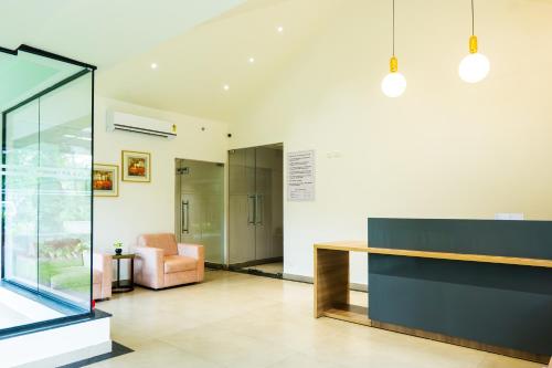 a lobby with a desk and a chair at Hotel Riviera Garden in Cochin