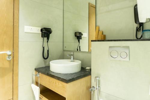 a bathroom with a sink and a mirror at Hotel Riviera Garden in Cochin