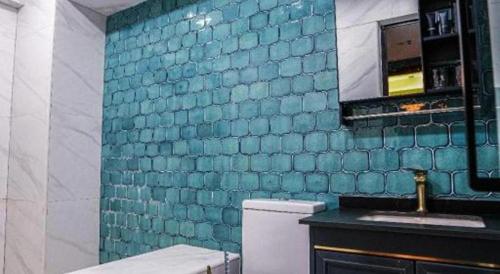 a bathroom with a blue tiled wall and a sink at Sunny Day Hotel in Hong Kong