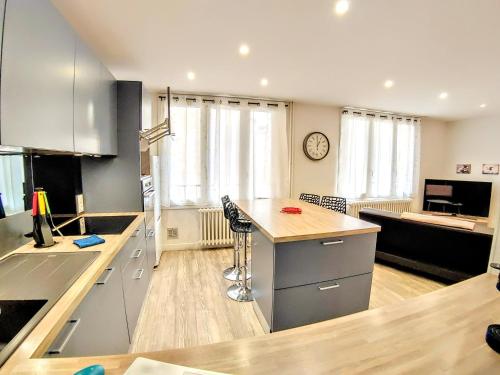 a kitchen with a counter top and a living room at Une halte, Proche Notre-Dame in Rodez