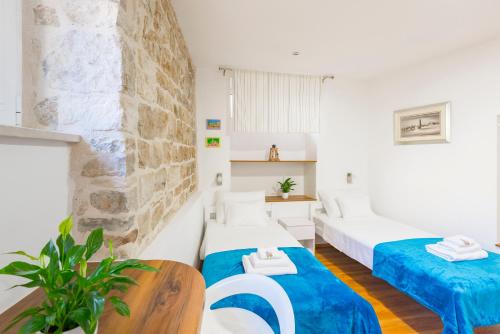 a hotel room with two beds and a table at Agata House Hvar in Hvar