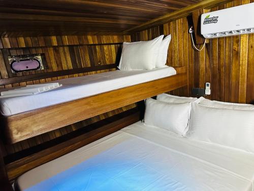 two beds in a room with wooden walls at Flying Fish in Male City