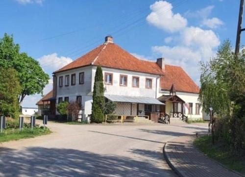 a large white building with a red roof at Stara Karczma Sypitki in Sypitki