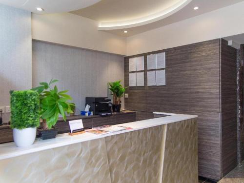 an office lobby with a reception counter with plants at Metroplace Boutique in Hong Kong