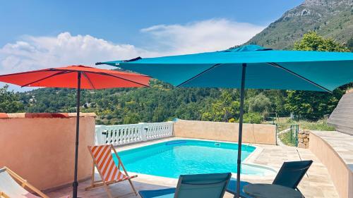 two umbrellas and chairs next to a swimming pool at Chambres d'hôtes Les Nymphéas in Revest-les-Roches