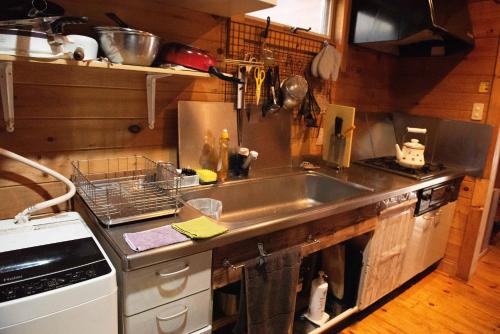 a kitchen with a sink and a stove at ジラソーレ北軽井沢 in Tsumagoi