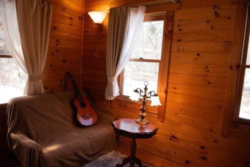 a bedroom with a guitar and a bed with a table at ジラソーレ北軽井沢 in Tsumagoi