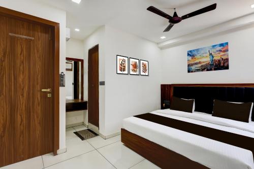 a bedroom with a bed and a ceiling fan at Hotel O Shubh Sankalp in Ahmedabad
