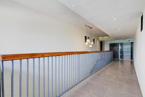 a hallway with a white wall and a railing at Hotel O Shubh Sankalp in Ahmedabad