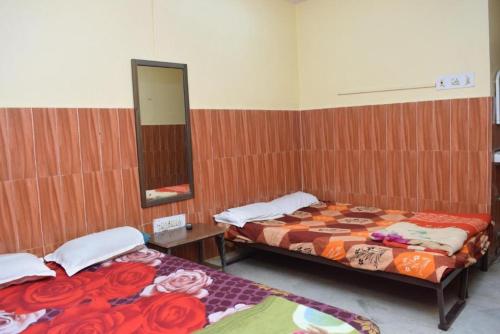 two beds in a room with a mirror at HOTEL SREE SAVITRI Near Shree Baba Baidyanath Jyotirlinga Temple - Free Wifi And Parking Facilities - Spacious and Fully Air Conditioned Rooms - Best Hotel In Deoghar in Deoghar