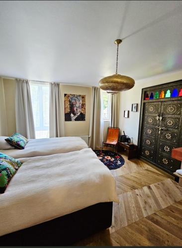 a bedroom with two beds and a chair in it at La Villa du Clos Normand Les Petites Dalles - Maison d'hôtes in Saint-Martin-aux-Buneaux