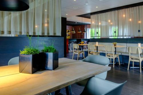 um restaurante com uma mesa de madeira e cadeiras e mesas e cadeiras em Zleep Hotel Ballerup em Ballerup