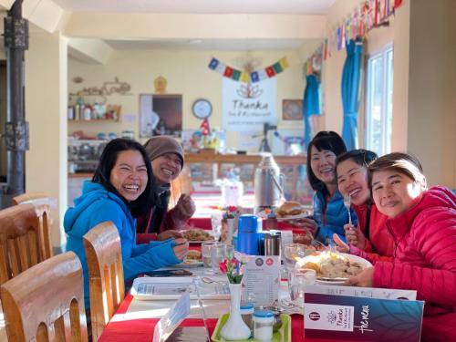 a group of people sitting at a table eating at Gokyo Thanka Inn in Khumjung