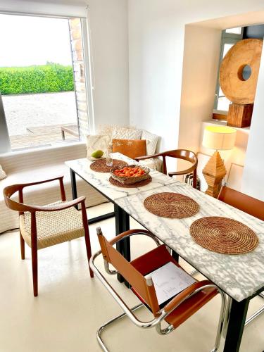 une salle à manger avec une table et des chaises blanches dans l'établissement Galerie, Tumulus de la Hogue, à Fontenay-le-Marmion