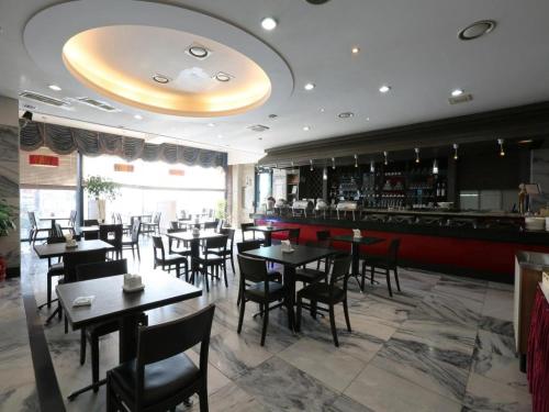 a restaurant with tables and chairs and a bar at Metro Tourist Hotel Cheonan in Cheonan