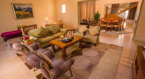 a living room with a couch and chairs and a table at Ocean Spring Metropark Hotel Zhuhai in Zhuhai