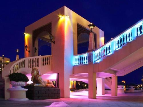 a building with a statue in front of it at night at Ocean Spring Metropark Hotel Zhuhai in Zhuhai