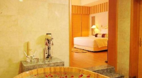 a bathroom with a bed and a tub in a room at Ocean Spring Metropark Hotel Zhuhai in Zhuhai