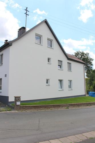 a white building on the side of a street at Apartment mit Küche, 2 Einzelbetten, Dusche, Parkplatz, schnellem Internet, ADA7 in Kulmbach