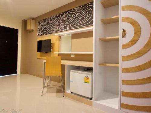 Kleines Zimmer mit einem Schreibtisch und einem Stuhl in der Unterkunft The Rice Hotel in Roi Et