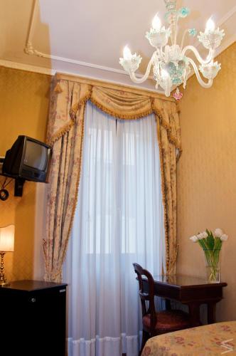 a bedroom with a window with a chandelier at Residenza d'Epoca San Cassiano in Venice