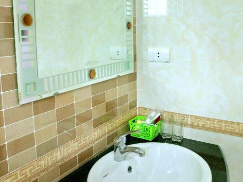 a bathroom with a sink and a mirror at Ngoc Bach Hotel in Mai Chau