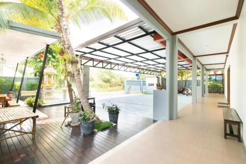 an open patio with palm trees and tables and benches at OYO 732 Juthamas Hotel in Patong Beach