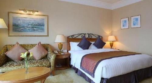 a hotel room with a bed and a couch at Regency Hotel in Shantou