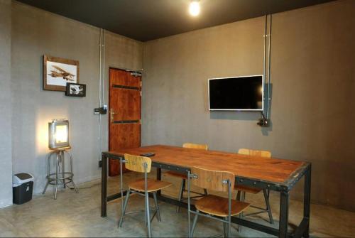 a dining room with a wooden table and chairs at Rider bedroom hostel & cafe in Hua Hin
