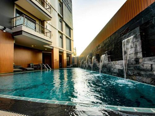 The Y Boutique Hotel في شيانغ ماي: حمام سباحة في فندق مع نافورة مياه