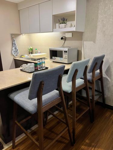 a kitchen with a table with chairs and a microwave at FirIzzkey Studio in Kota Bharu