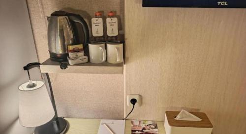 a miniature kitchen with a coffee maker on a shelf at Fovere Hotel Palangkaraya in Palangkaraya