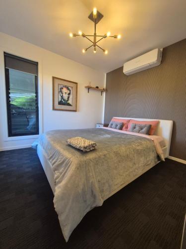 a bedroom with a large bed with a fan at RESIDENTIAL 4 BEDROOM House in Coffs Harbour