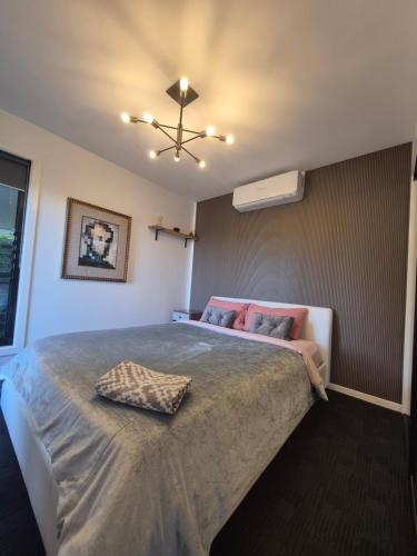 a bedroom with a large bed with a ceiling fan at RESIDENTIAL 4 BEDROOM House in Coffs Harbour