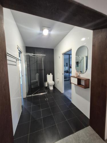 a bathroom with a shower and a toilet and a sink at RESIDENTIAL 4 BEDROOM House in Coffs Harbour