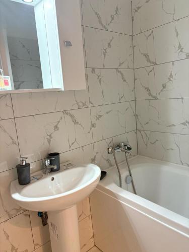 a bathroom with a sink and a bath tub and a sink at Studio Alice Mia in Chiajna