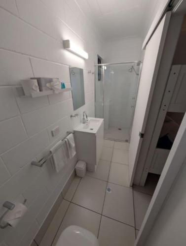 a bathroom with a sink and a toilet and a shower at Moffat Beach Motel Caloundra in Caloundra