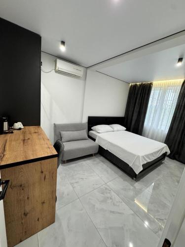 a bedroom with a bed and a chair and a desk at Nika house in Ureki
