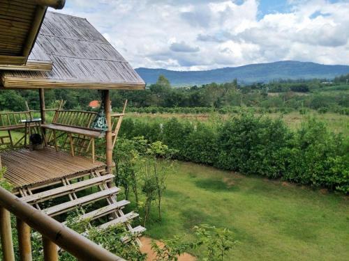 a porch of a house with a view of a field at Baansuanpai Noppakao in Pong Talong