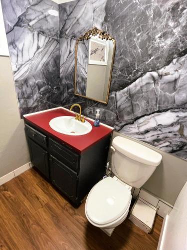 a bathroom with a white toilet and a sink at Shiraz Suite in Calgary