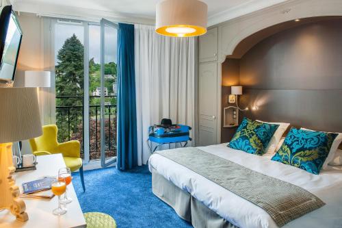 ルルドにあるGrand Hôtel Gallia & Londres Spa NUXEのベッドとバルコニー付きのホテルルーム