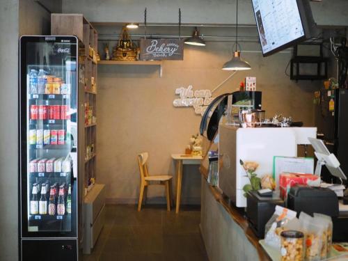 a coffee shop with a counter and a table with a chair at Tanban Mansion in Surin